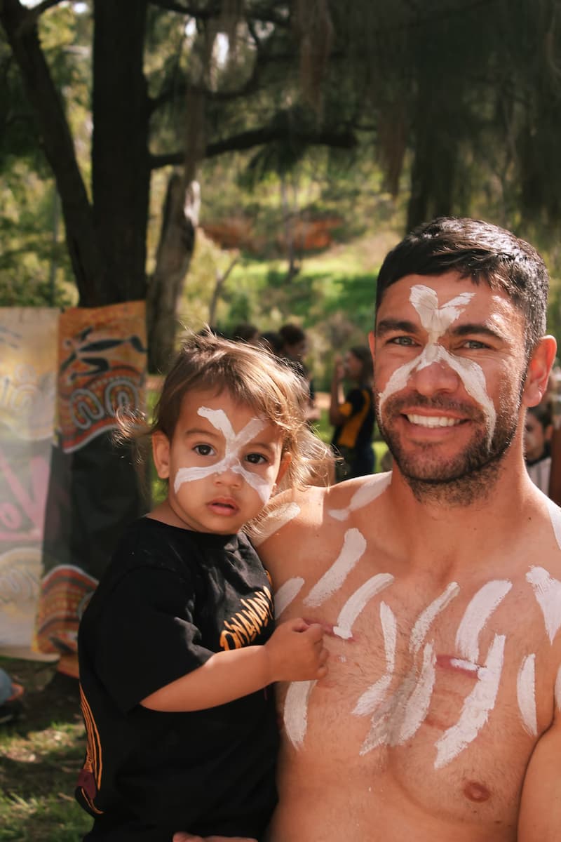Father and child with traditional face paint