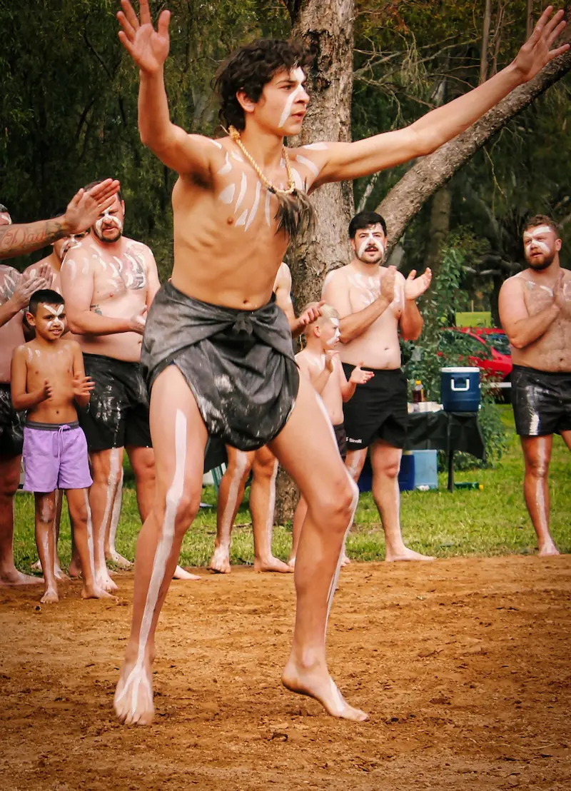 Young man performing traditional dance with body paint